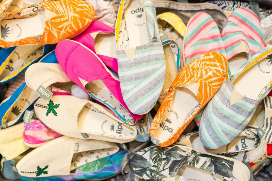 A lot of alpargatas piled together, with diferent colors and patterns. Alpargatas are a footwear similar to sandals.